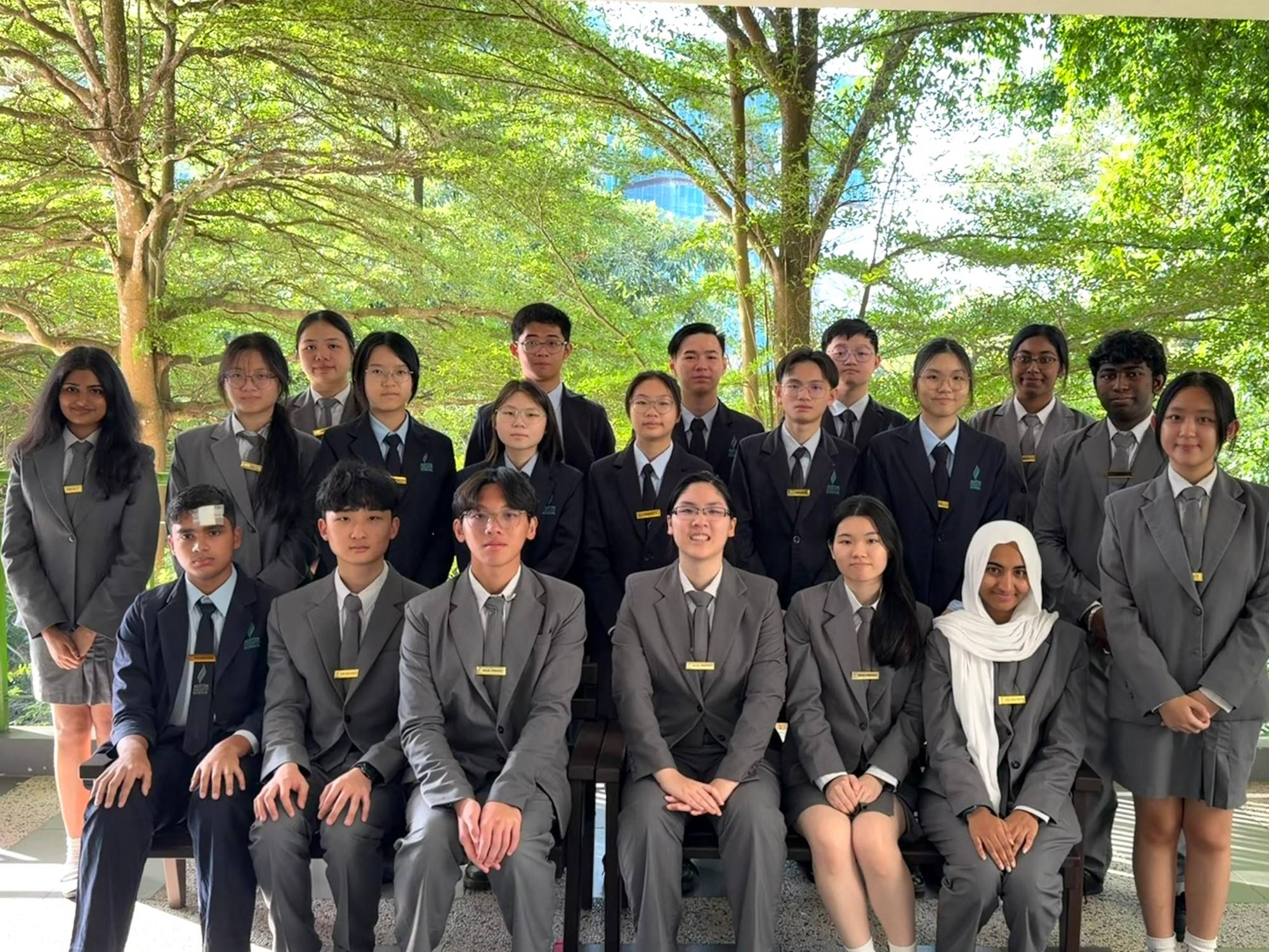 The Austin Heights prefect board in uniform, seated and standing in two rows under the trees